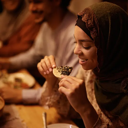 Une femme déguste un repas après avoir suivi les règles du jeûne de Ramadan.